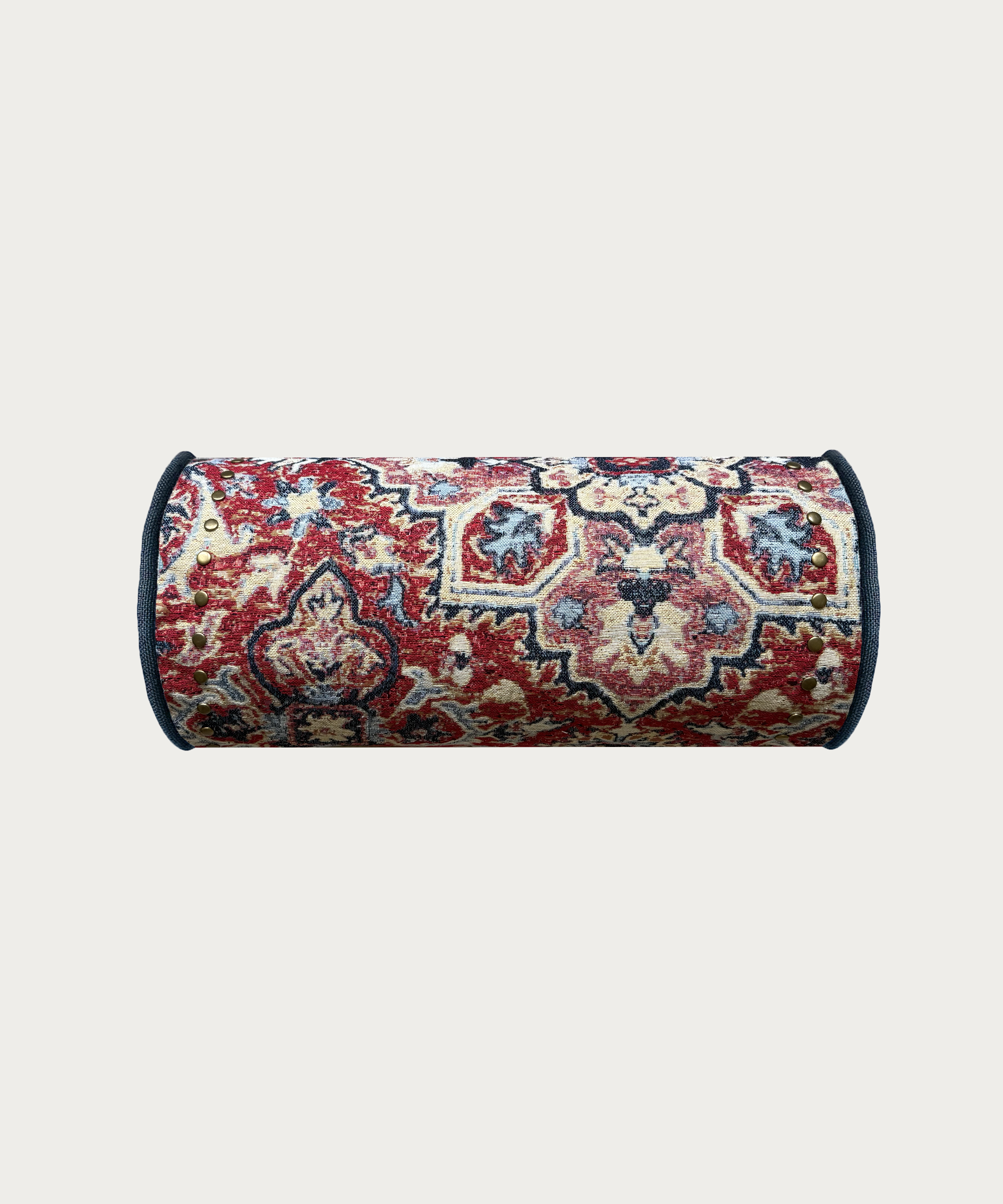red bolster cushion with stud trim and blue piping made in england