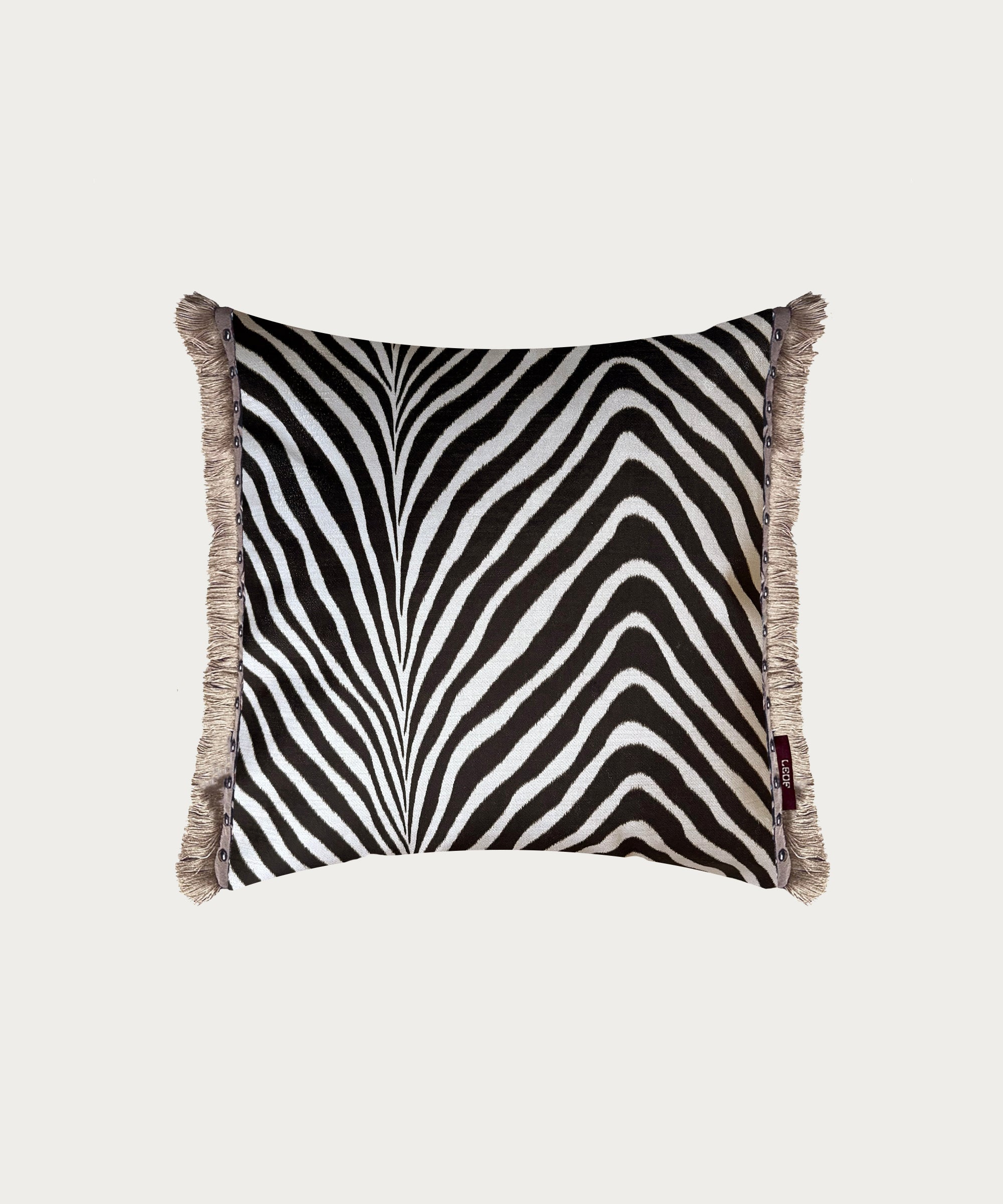 square zebra print cushion with stud trim and cotton fringe made in england